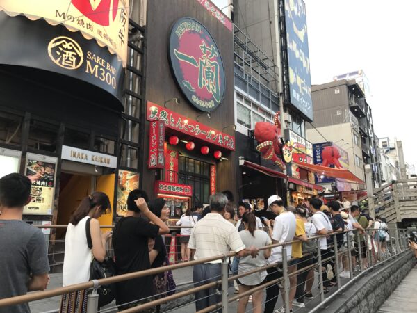 Lange Schlange mit chinesischen Touristen vor einer Ramen-Filiale in Osaka