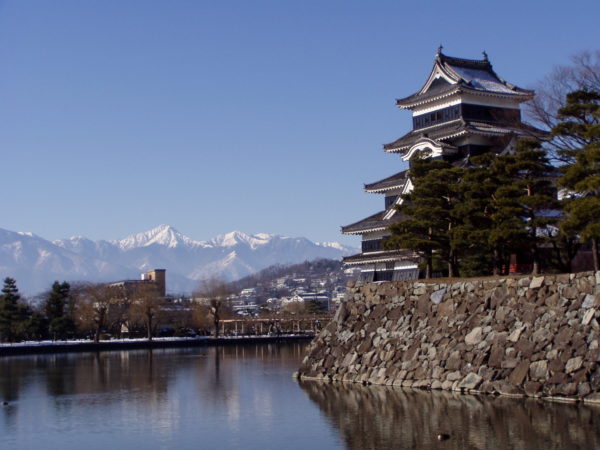 Donjon und Mizuhori der Burg von Matsumoto (Matsuyama-jō), im Hintergrund die Nordalpen